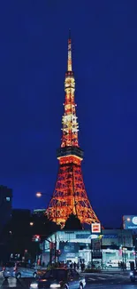 Illuminated Tokyo Tower against a dark blue night sky with city lights.