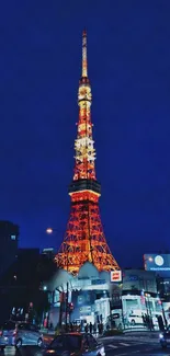 Tokyo Tower illuminated against a dark blue sky at night.