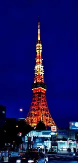 Tokyo Tower illuminated against a navy blue night sky with vibrant city lights.