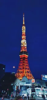 Tokyo Tower glowing at night with dark blue sky backdrop.