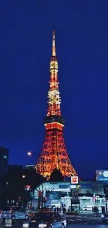 Tokyo Tower illuminated at night with vibrant city lights and a deep blue sky.