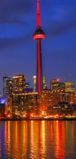 Night view of Toronto skyline and CN Tower reflected over water.