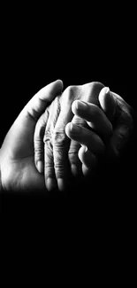 Black and white hands symbolizing empathy and connection on a dark background.