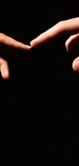 Two hands reaching out on a dark background wallpaper.