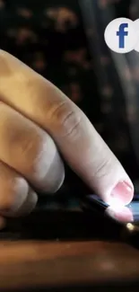 Close-up of a finger interacting with a smartphone screen in warm lighting.