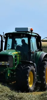 Green tractor working in a peaceful field scene.