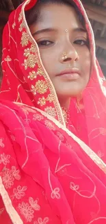 Woman in red traditional attire with gold embroidery.