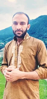 Man in traditional attire with scenic mountain background.