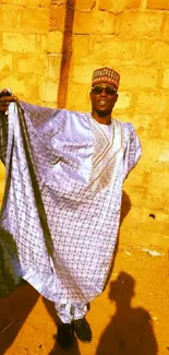 Man in traditional attire under golden sunlight casting shadows.