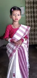 Young child in traditional attire, posing gracefully.