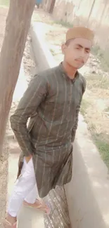 Young man in traditional attire outdoors.