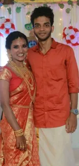 Duo wearing traditional attire with festive decorations.