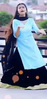 Woman in traditional dance on outdoor balcony.