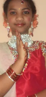 Portrait of a person in traditional attire with vibrant red dress and jewelry.