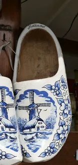 Traditional Dutch clogs with blue windmill and floral patterns hanging for display.