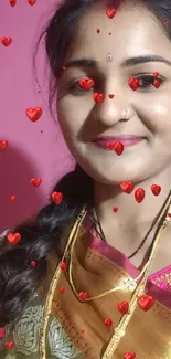 Traditional Indian woman in colorful saree and jewelry against pink background.