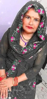 Portrait of a woman in traditional attire with floral embroidery and vibrant bangles.