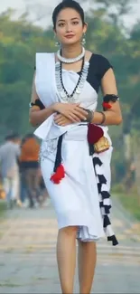 Woman in traditional attire walking on a scenic path.