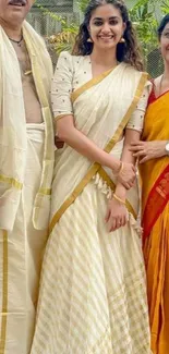 Family in elegant traditional attire smiling outdoors.