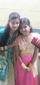 Two girls in traditional festive attire posing together.