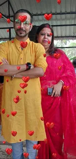 Two people in vibrant traditional attire pose in an outdoor setting.