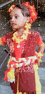 Child in traditional attire with floral decor on stairs.