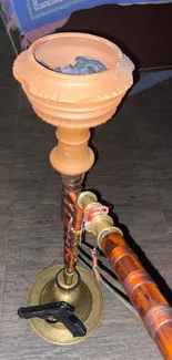 Traditional hookah pipe on rustic wooden floor.