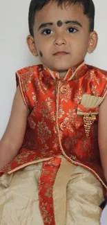 Child in traditional Indian attire with floral embroidery.