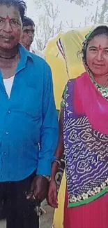 Indian couple in traditional attire with colorful sarees.