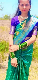 Woman in vibrant green saree standing outdoors.