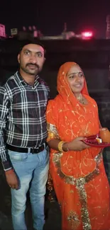 Indian couple in traditional attire during a night event.