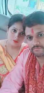 Indian couple in traditional attire in a car.