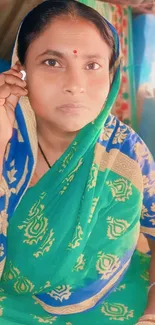 Woman in traditional green sari, vibrant cultural wallpaper.