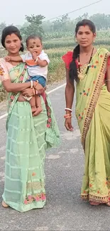 Women in colorful saris walking on a country road.