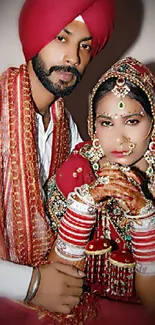 Elegant Indian wedding couple in traditional attire with vibrant red and gold accents.