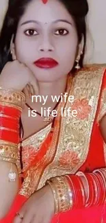 Woman in vibrant red saree with jewelry, posing elegantly.