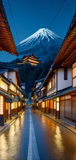 Japanese street leading to a snow-capped mountain at night.