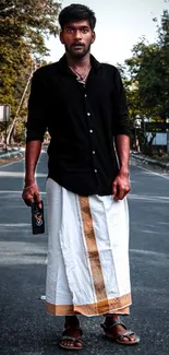 Man in traditional attire on a quiet street.