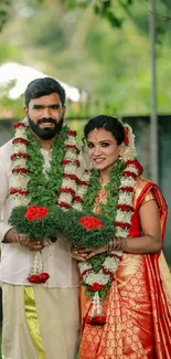 Traditional wedding couple with garlands.