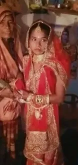 Traditional bride in red wedding attire with gold accents.