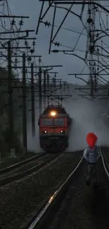 Train approaches on dark misty tracks at night, creating an atmospheric scene.