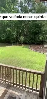 A tranquil view of a green backyard from a wooden deck.