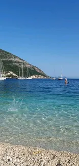 Serene beach with sailboats and clear blue sky wallpaper.