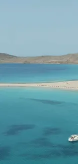 Tranquil beach view with sailboat and turquoise waters.