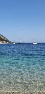 Peaceful beach with sailboats and clear blue ocean