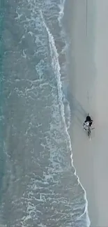 A lone cyclist rides along a tranquil beach.