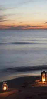 Tranquil beach scene at sunset with glowing lanterns by the ocean.