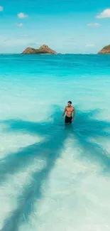 A man walks through turquoise waters under a blue sky with distant islands.