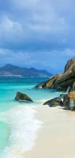 Tropical beach with clear water and rocks under a blue sky.