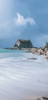 Tranquil ocean wallpaper with rocks and blue sky on beach.